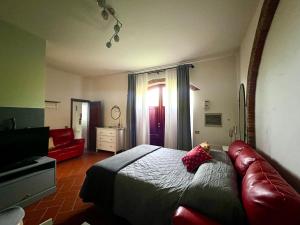 - une chambre avec un lit et un canapé rouge dans l'établissement Casa della Noce, à Vinci