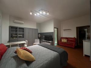 - une chambre avec un lit et un canapé rouge dans l'établissement Casa della Noce, à Vinci
