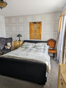 a bedroom with a large bed and a chair at Sea Song, Selkie House in Helmsdale