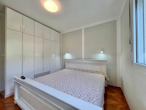 een slaapkamer met een bed en witte kasten bij Melanie- City Centre Apartment in Herceg-Novi