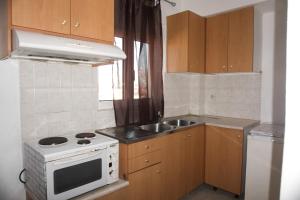 a small kitchen with a stove and a sink at Sea in Adelianos Kampos