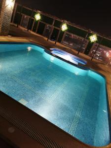 an empty swimming pool at night with lights at ابراج التحلية ريزيدنس Tahlia Towers Residence in Al Khobar