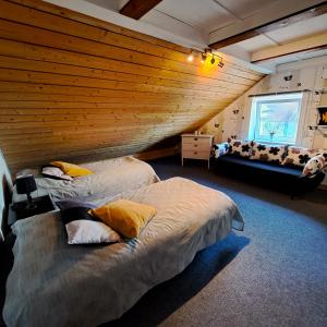 2 camas en una habitación con pared de madera en Unique rustic property in skåne en Linderöd