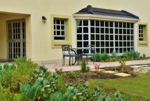 un patio con una mesa frente a una casa en Road lodge Hotel Cape Town International Airport -Booked Easy en Ciudad del Cabo