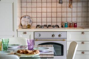 a kitchen with a stove and a table with a plate of bread at L'alba di Santa Cesarea in Santa Cesarea Terme