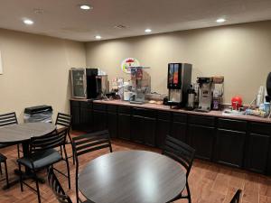 a restaurant with two tables and a counter with machines at Super 8 by Wyndham Winfield-Quail Ridge Area in Winfield