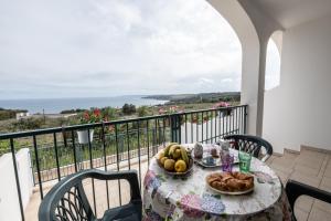 a table with a plate of fruit on a balcony at L'alba di Santa Cesarea in Santa Cesarea Terme