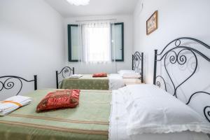 two beds in a room with white walls at L'alba di Santa Cesarea in Santa Cesarea Terme