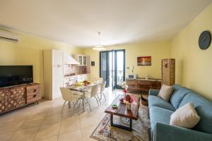 a living room with a blue couch and a kitchen at L'alba di Santa Cesarea in Santa Cesarea Terme