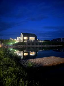 un bâtiment sur la rive d'un lac la nuit dans l'établissement Biała Woda, à Suwałki