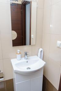 a bathroom with a white sink and a mirror at WhiteHome Apartment in Xanthi