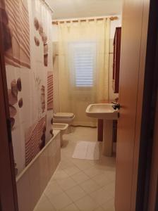 y baño con aseo, lavabo y ducha. en B & B Villa Lucia, en Noci