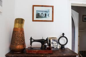 a table with an antique sewing machine and a picture at Riyad zen oasis in Essaouira