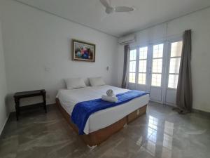 a bedroom with a large bed with a blue blanket at Wafeh Fleming Suítes Pampulha in Belo Horizonte