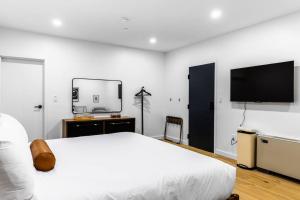 a bedroom with a white bed and a flat screen tv at King Bed , DTWN, 50 in Roku TV , Fiber Internet, Room # 203 in Bangor