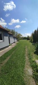 a field of grass next to a house at Moonlight Apartman in Sárospatak