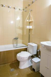 a bathroom with a toilet and a tub and a sink at WhiteHome Apartment in Xanthi
