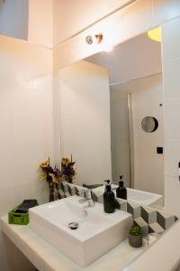 La salle de bains est pourvue d'un lavabo blanc et d'un miroir. dans l'établissement Casa Miguel - Apartamento 3, à Sanlúcar de Barrameda