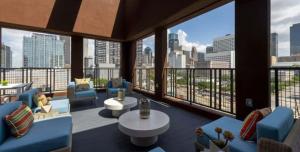 a living room with a view of a city skyline at SODO City Gem: Rooftop Skyline Pool Parking Wi-Fi in Houston