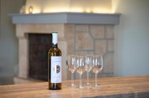 uma garrafa de vinho sentada numa mesa com copos de vinho em Oinopia Apartments em Aegina Town