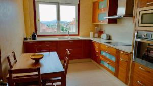 a kitchen with a table and a window and a sink at Casa Ría de Vigo in Moaña
