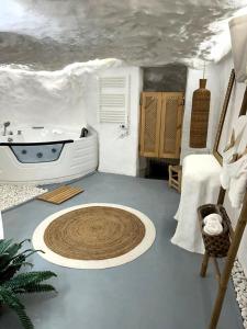 a bathroom with a tub and a sink in a room at La Cueva Blanca in Alcalá del Júcar