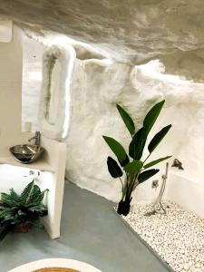 een badkamer met een potplant naast een bad bij La Cueva Blanca in Alcalá del Júcar
