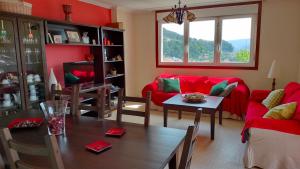 ein Wohnzimmer mit einem roten Sofa und einem Tisch in der Unterkunft Casa Ría de Vigo in Moaña