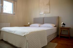 um quarto com uma cama branca e uma janela em Oinopia Apartments em Aegina Town