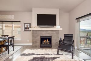 a living room with a fireplace with a flat screen tv at Rendezvous 47 Lookout Point in Fraser