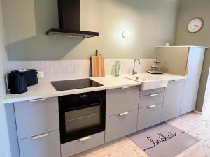 a kitchen with a sink and a stove at Ker Alinec la Dépendance in Paimpol