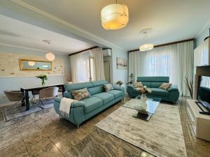 una sala de estar con 2 sofás azules y una mesa. en Apartments Ragusa, en Rovinj