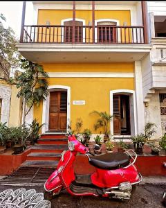 FRENCH RIVERA Heritage Boutique Villa في بونديتْشيري: سكوتر حمراء متوقفة أمام منزل