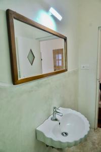 FRENCH RIVERA Heritage Boutique Villa في بونديتْشيري: حمام مع حوض ومرآة