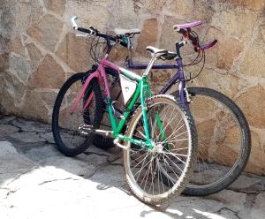 2 biciclette sono parcheggiate accanto a un muro di pietra di La torna a Navarredonda de Gredos