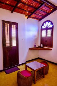 FRENCH RIVERA Heritage Boutique Villa في بونديتْشيري: غرفة بها طاولة وكرسيين ونافذة