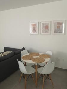 a table and chairs in a living room with a couch at Casa Merlín Arena in Playa Honda