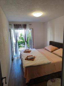 een slaapkamer met twee bedden en een groot raam bij Apartment Ruža in Trogir