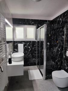 een badkamer met toilet, wastafel en douche bij Apartment Ruža in Trogir