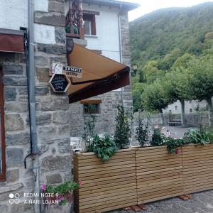 een gebouw met een houten hek met planten bij Albergue Armaia Artepea in Urzainqui