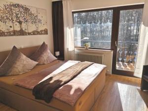 a large bed in a room with a large window at Hotel Waldsee in Waldachtal