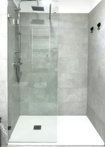 a shower with a glass door in a bathroom at Sole Matto Rooms in Olbia