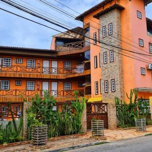 pomarańczowy budynek z roślinami przed nim w obiekcie Pousada Enseada da Vila w mieście Cabo Frio