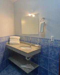 a bathroom with a sink and a mirror at Pousada Enseada da Vila in Cabo Frio