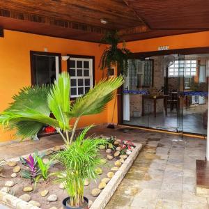 an orange house with a palm tree in the front yard at Pousada Enseada da Vila in Cabo Frio