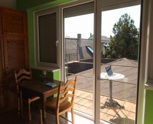 a room with a balcony with a table and a laptop at Müller's 1 in Siófok