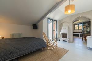 a bedroom with a bed and a living room with a fireplace at Suite familiale 2 chambres communicantes et piscine in Lacquy