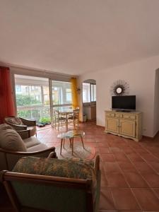 ein Wohnzimmer mit einem Sofa und einem Tisch in der Unterkunft T3 Ajaccio rte des Sanguinaires in Ajaccio