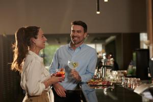 Ein Mann und eine Frau mit einem Glas Wein in der Unterkunft Holiday Inn Santiago - Airport Terminal, an IHG Hotel in Santiago