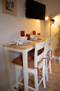 uma mesa de jantar branca com cadeiras e uma televisão em Countryside Loft in Bridgnorth em Bridgnorth